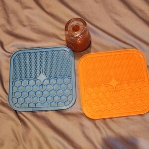 Blue and Orange Lick Mats For pets And A Toy That Holds treats In It.